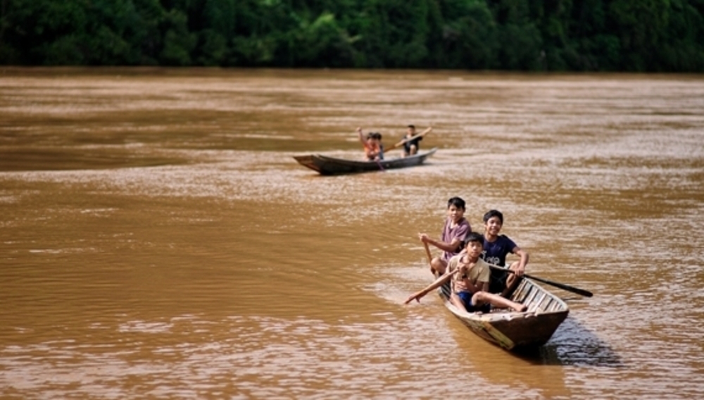 De jeunes enfants bravent le Mékong en pirogue, Kamu Lodge, Laos