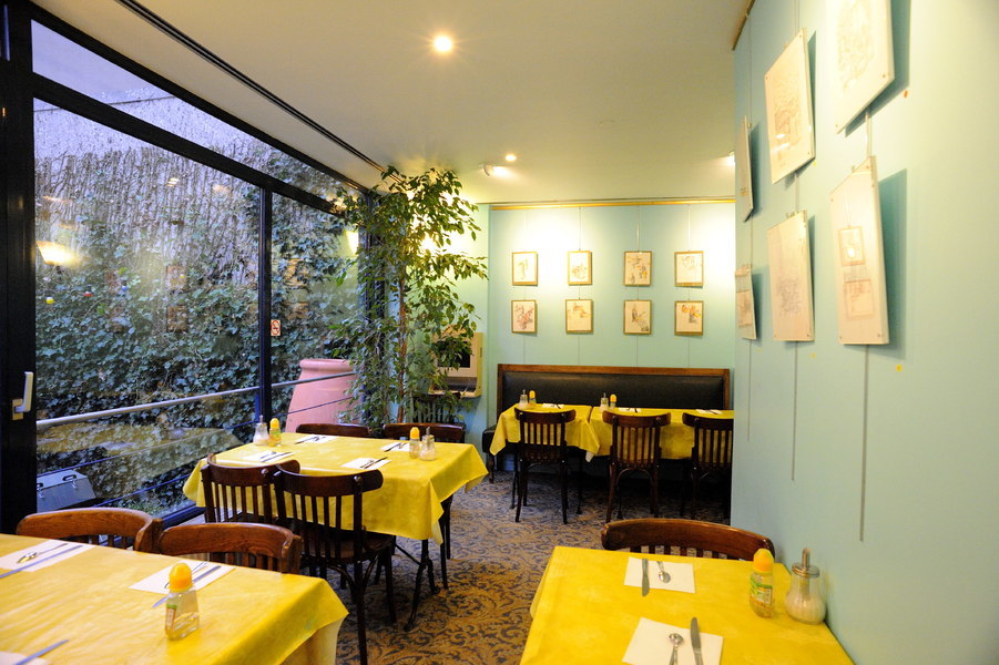 La salle du petit-déjeuner et la baie vitrée donnant sur le jardin
