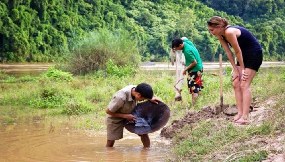 Un Laotien cherche de l'or dans la rivière, Kamu Lodge, Laos