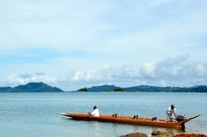 Deux habitants de la maison longue sur leur pirogue, Lac Batang Ai - Bornéo, Malaisie